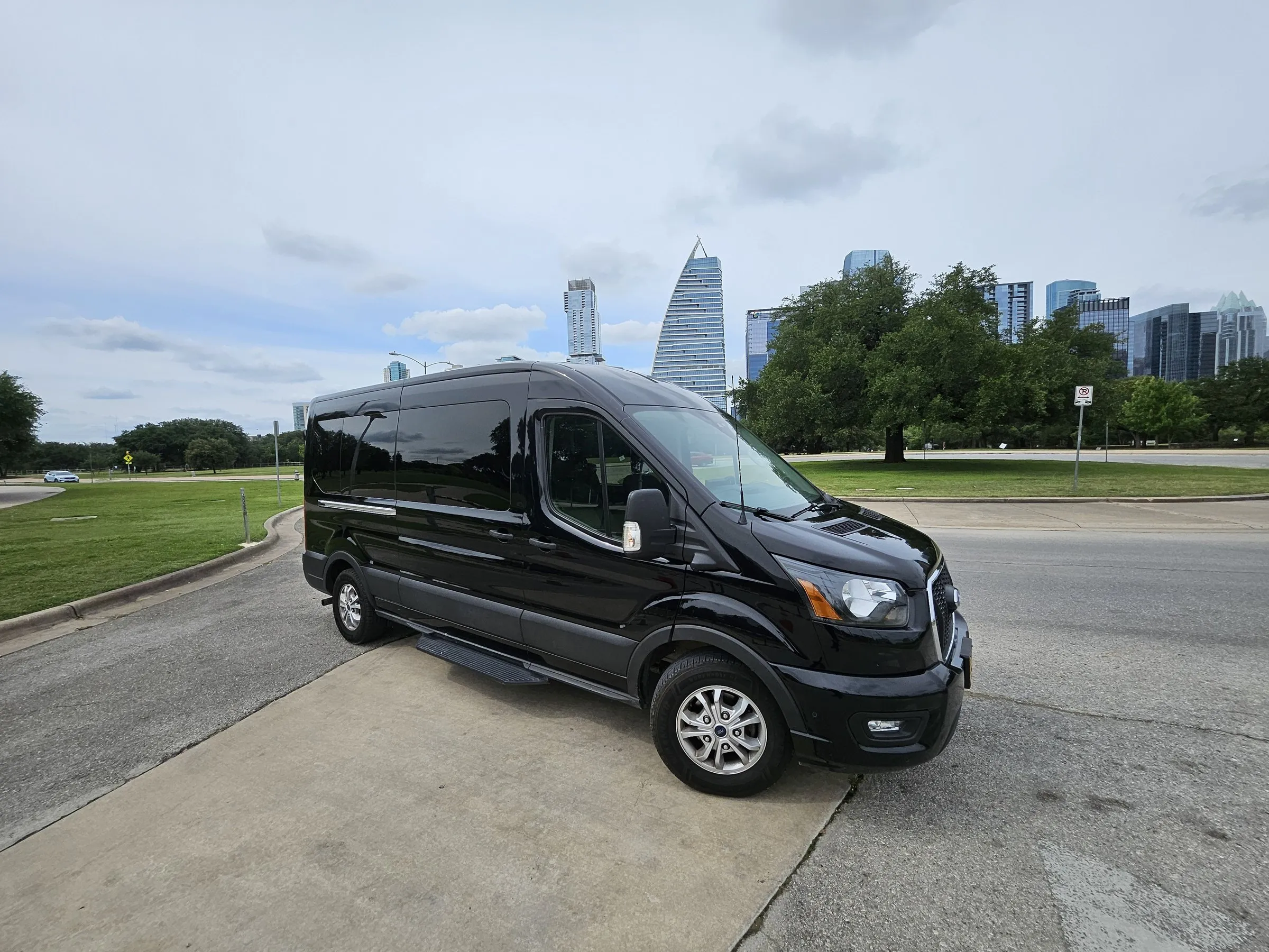 Lake Travis Limo black Ford Transit passenger van with the downtown Austin skyline