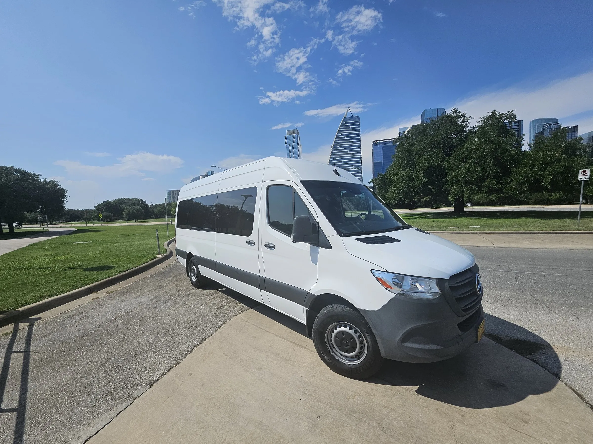 Lake Travis Limo white Mercedes-Benz Sprinter crew van for gear and luggage, downtown Austin skyline