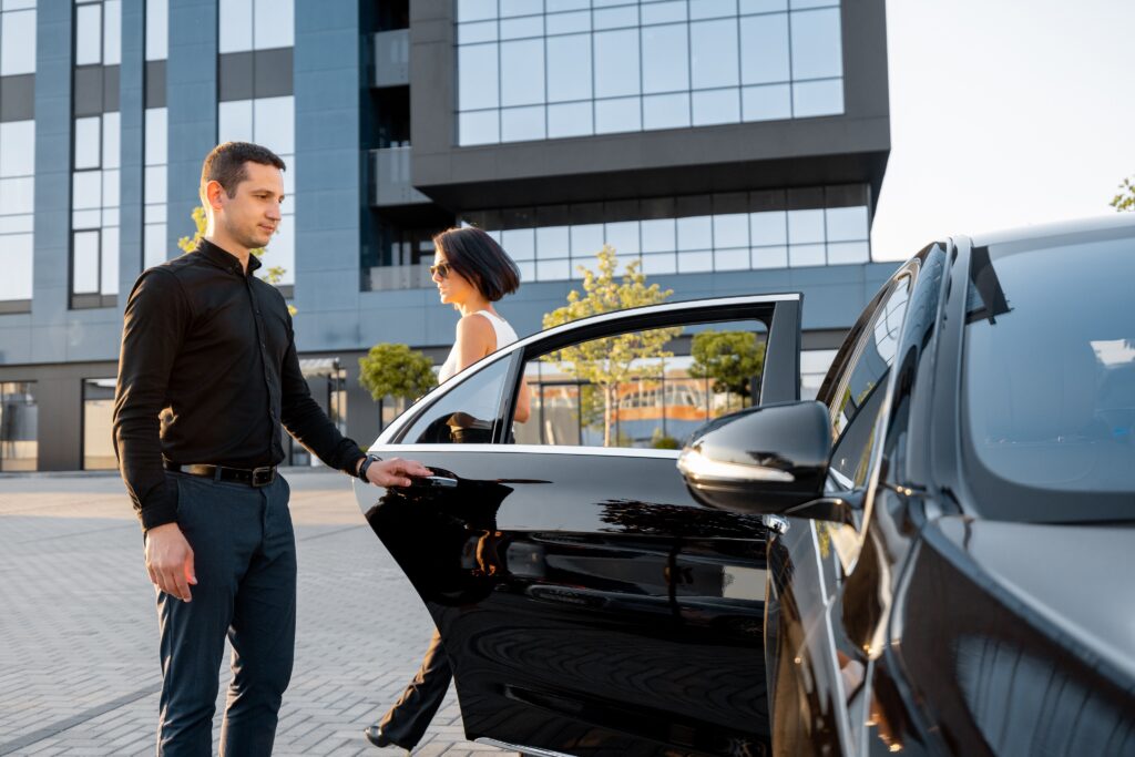 chauffeur helps an elegant business woman gets in its our dedication to quality, reliability, and customer satisfaction has earned us praise from clients across the region